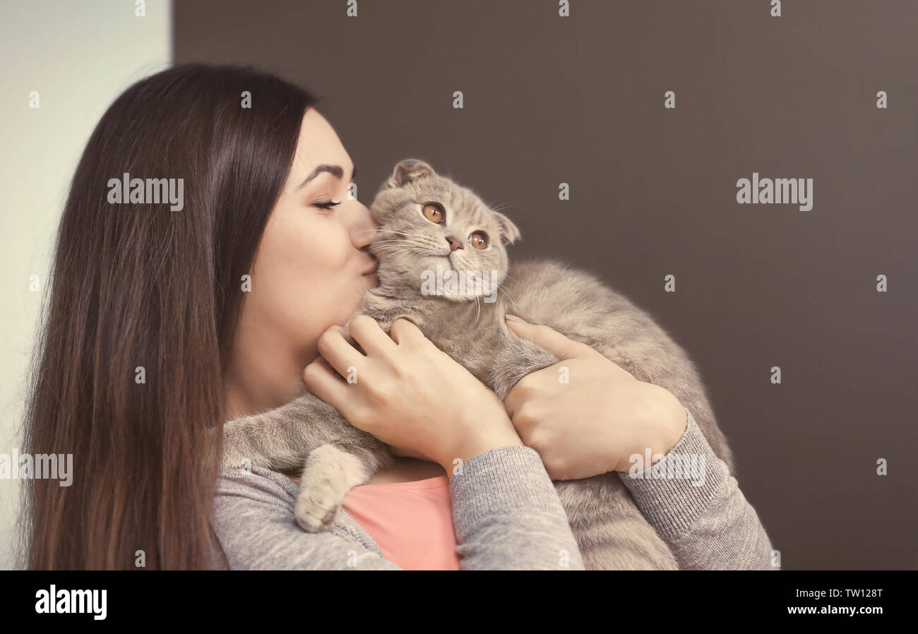 Beautiful young woman with cute cat resting at home Stock Photo