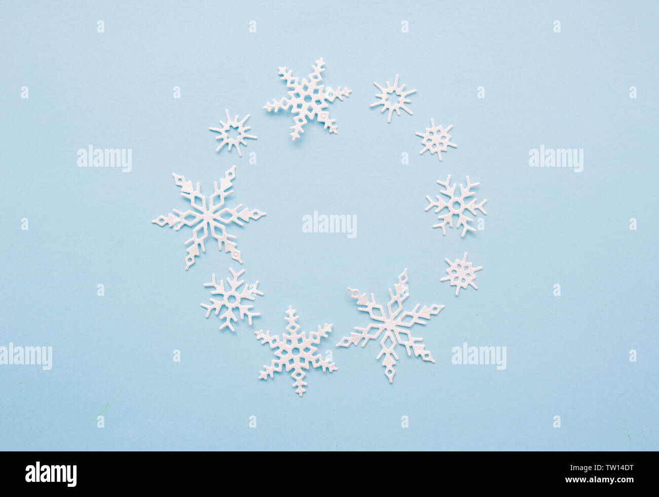 Christmas or winter composition wreath. Frame of white snowflakes on pastel blue background. Christmas, winter, new year concept. Flat lay, top view Stock Photo