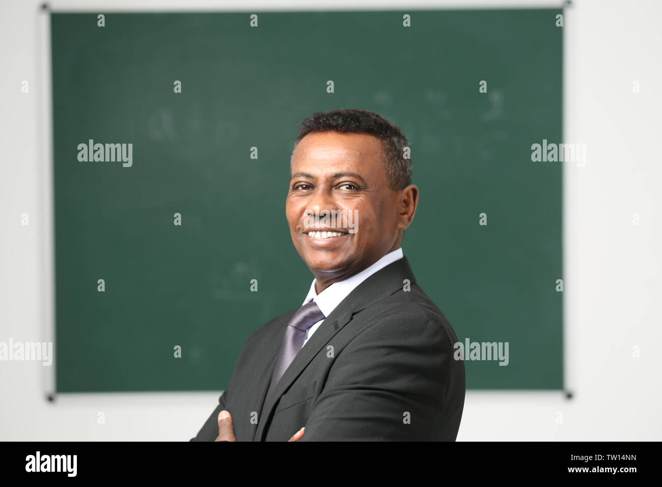 Confident Indian teacher in classroom Stock Photo