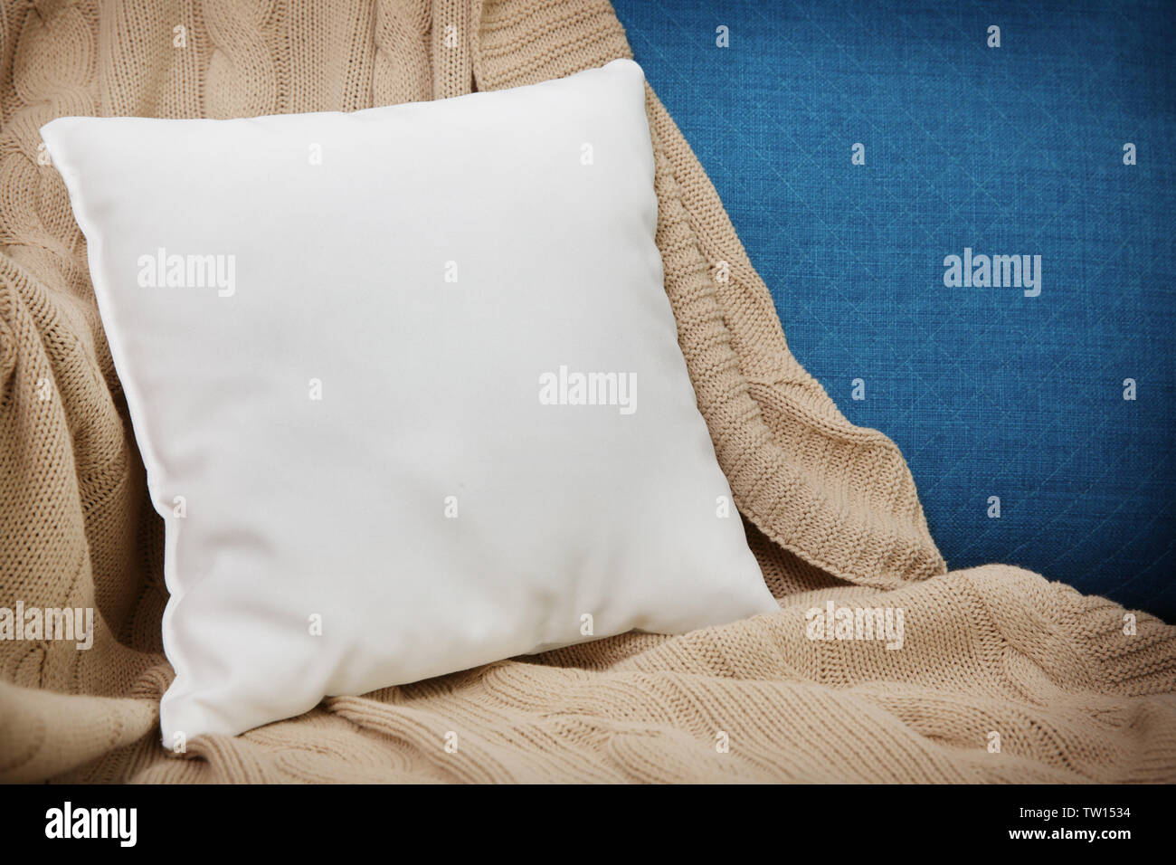 Blank soft pillow on cozy armchair Stock Photo