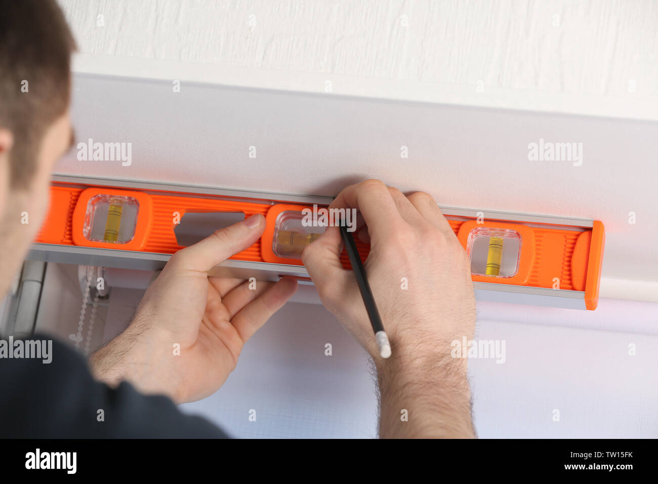Male hands making window measurements using  building level Stock Photo