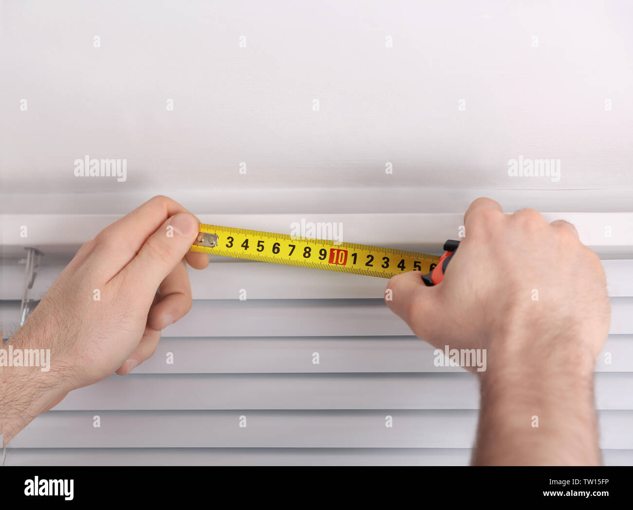 Male hands making window measurements Stock Photo