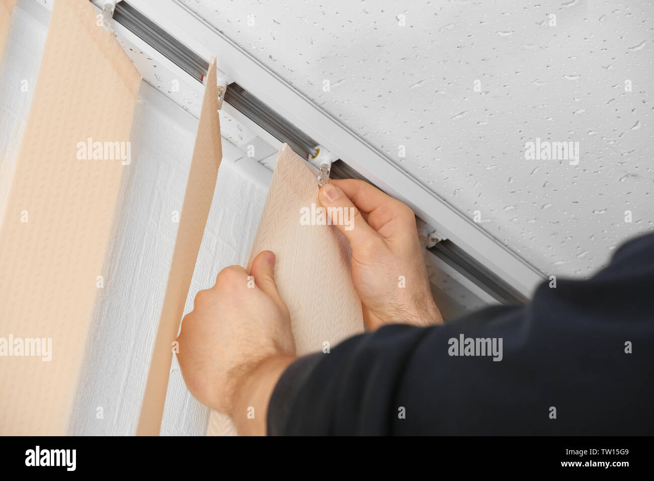 Male hands installing vertical blinds Stock Photo