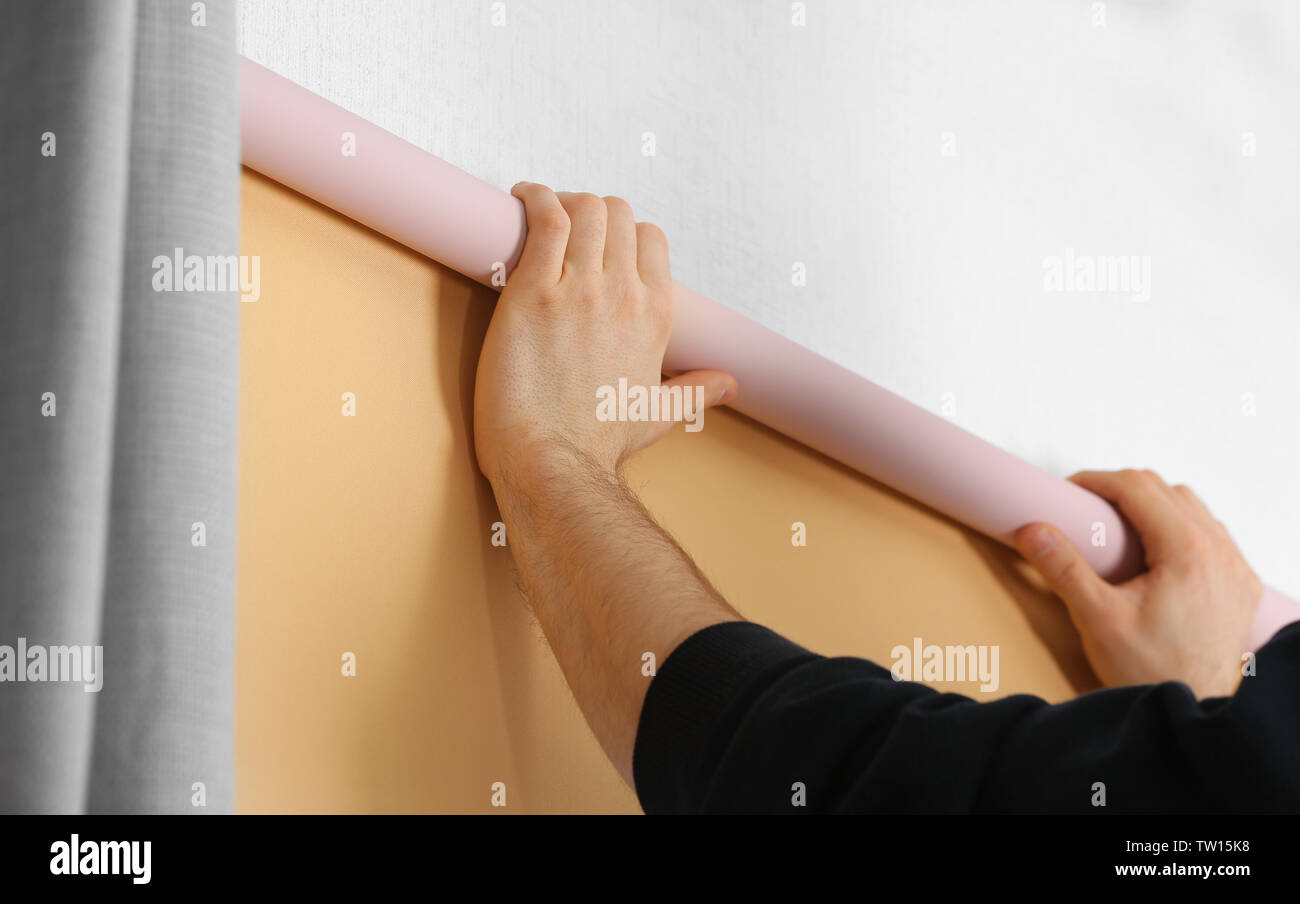 Male hands installing roller blinds on window Stock Photo