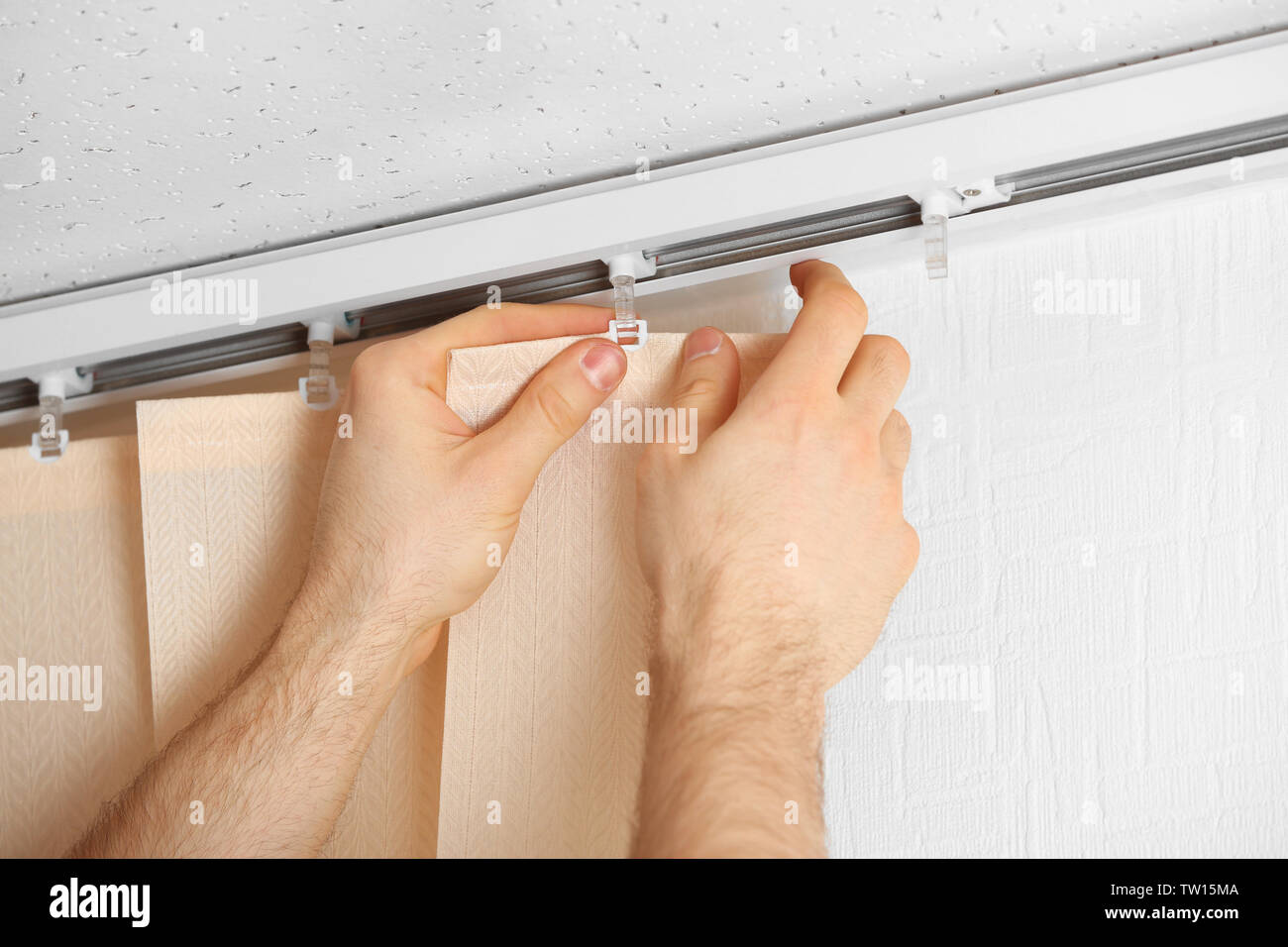 Male hands installing vertical blinds Stock Photo