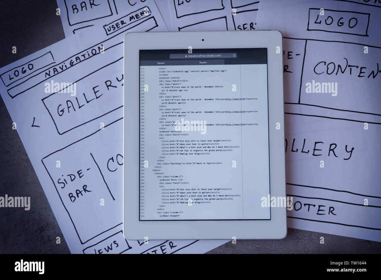 Tablet with programming code for website on table Stock Photo