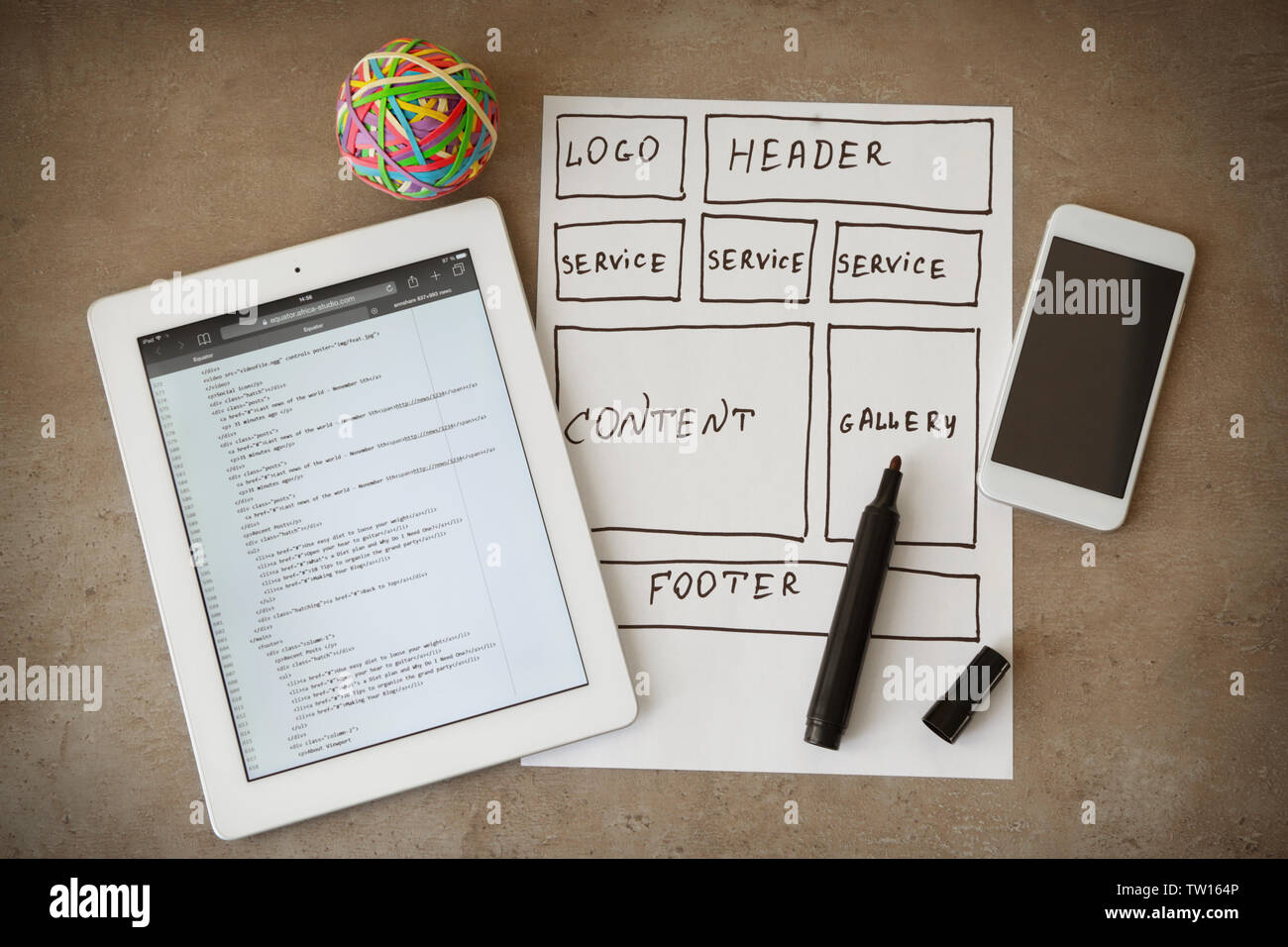 Tablet with programming code for website on table Stock Photo