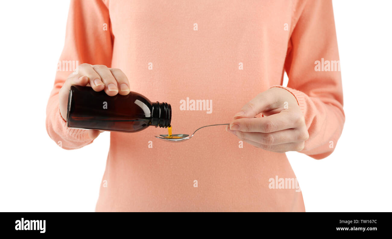 Woman pouring cough medicine syrup into spoon on white background Stock