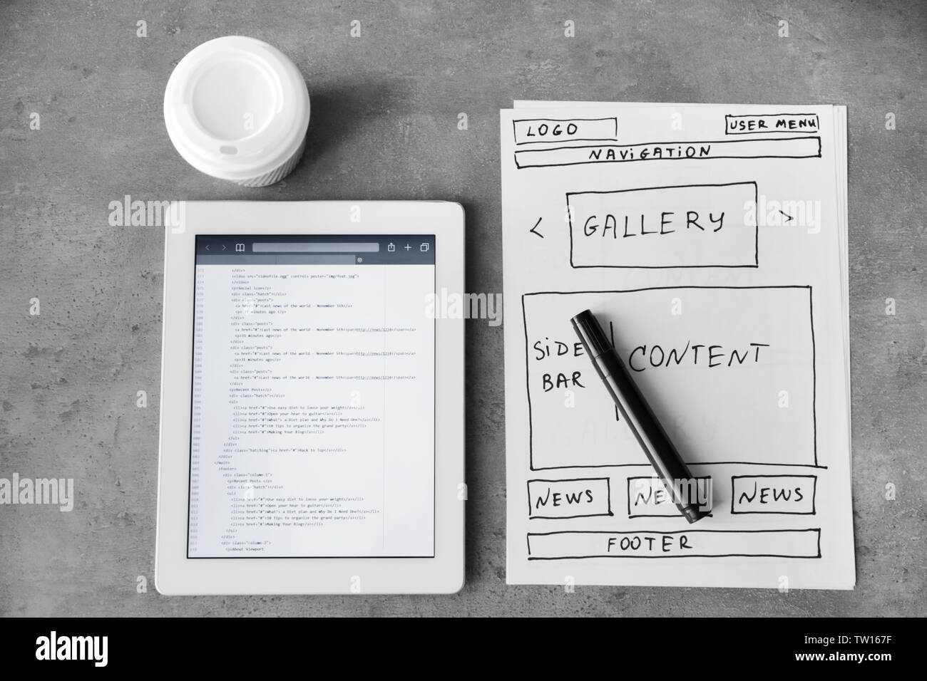Tablet with programming code for website on table Stock Photo