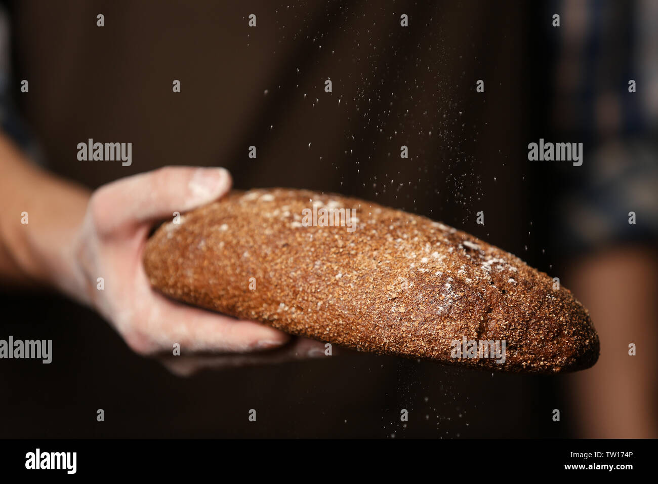 Male hand holding freshly baked rye bread, closeup Stock Photo - Alamy