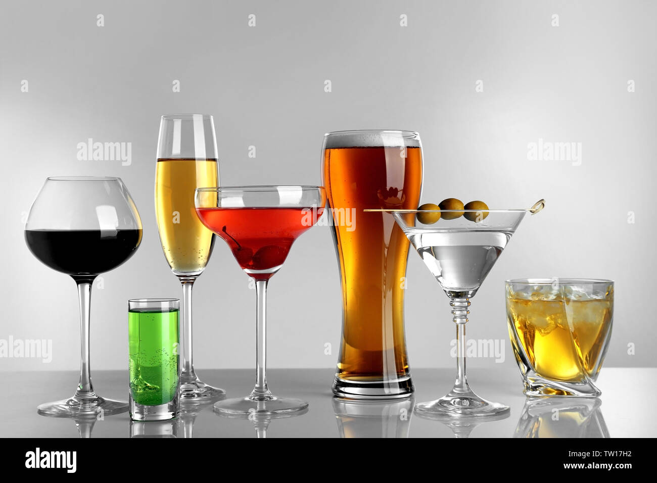 Glasses of wine and spirits on light background Stock Photo Alamy