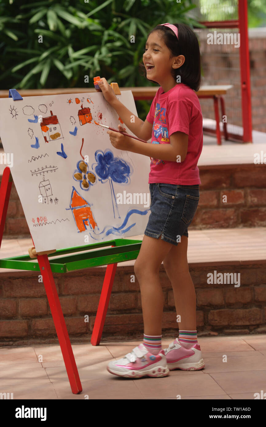 Girl painting at easel Stock Photo - Alamy
