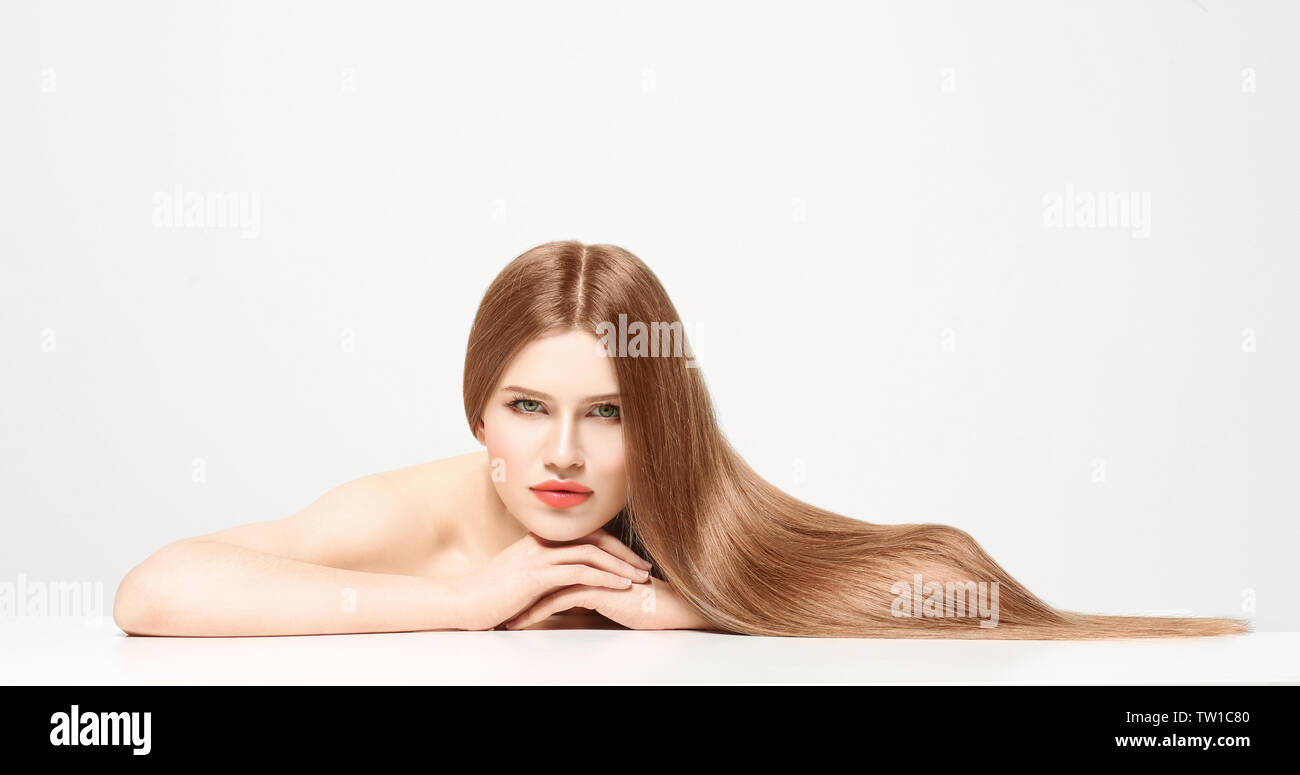 Attractive young woman with beautiful long hair on white background ...