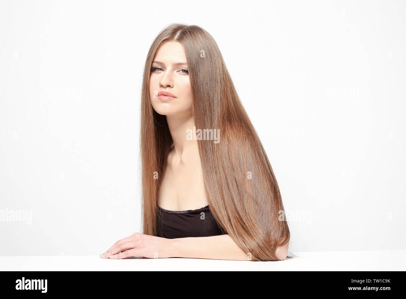 Attractive young woman with beautiful long hair on white background ...