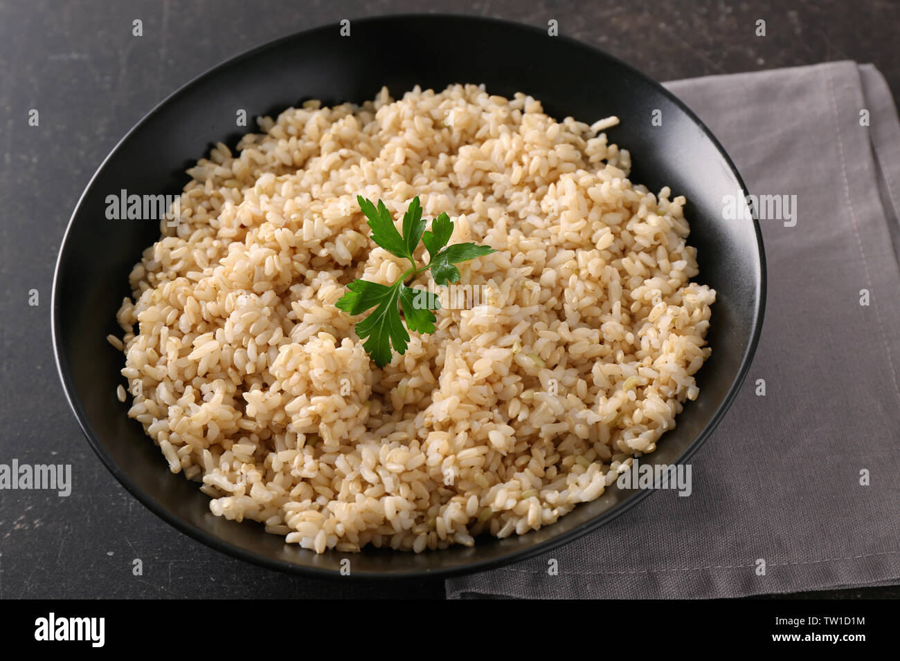 Plate with brown rice on gray table background Stock Photo - Alamy