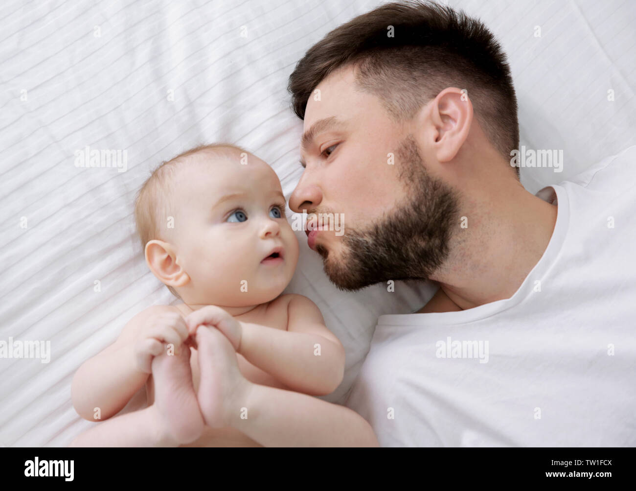 Father lying with cute baby daughter on bed at home Stock Photo - Alamy
