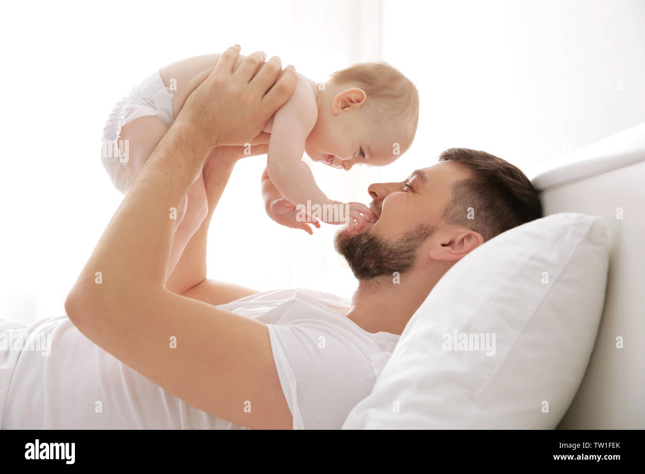 Father lying with cute baby daughter on bed at home Stock Photo - Alamy