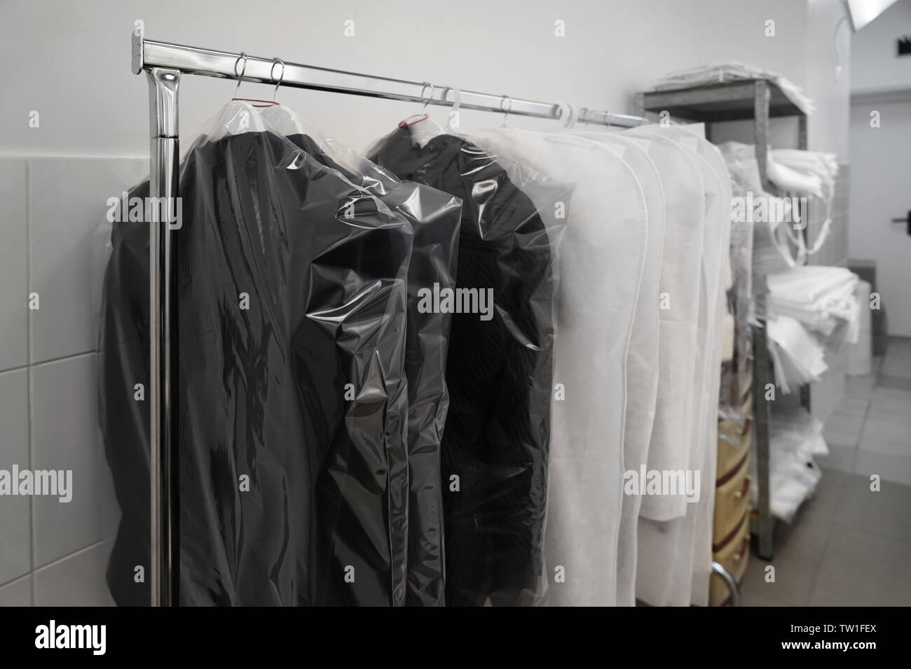 Concept of dry cleaning service. Hangers with clean clothes hanging on rack  Stock Photo - Alamy