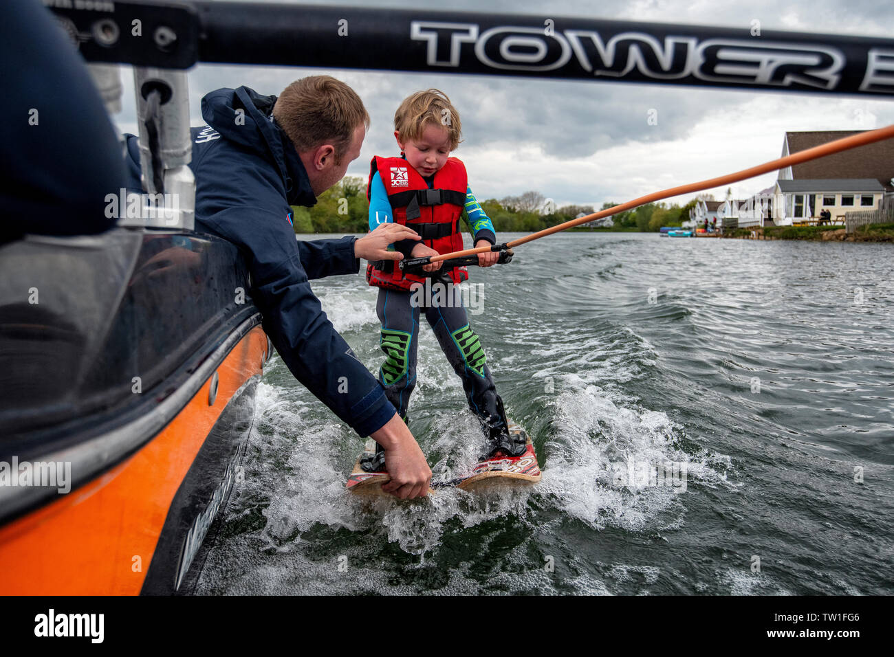 A five year old boy learns to waterski on a lake in the Cotswolds, Gloucestershire, England. Stock Photo
