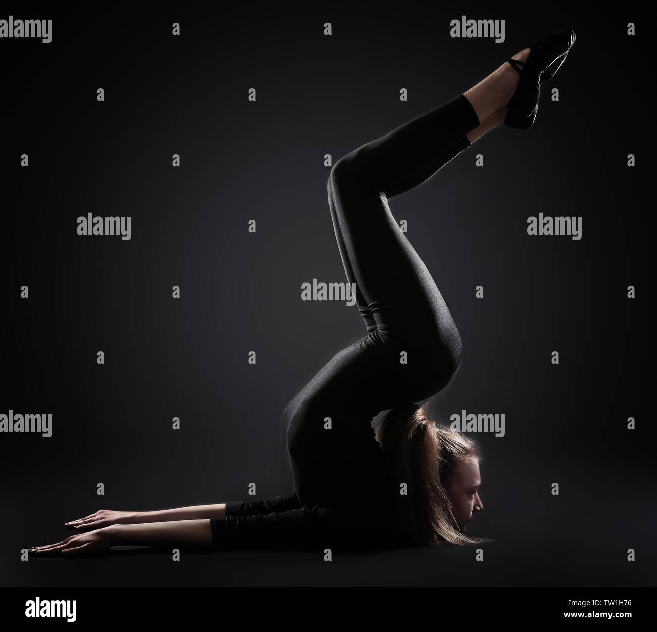 Young girl doing gymnastics on dark background Stock Photo - Alamy