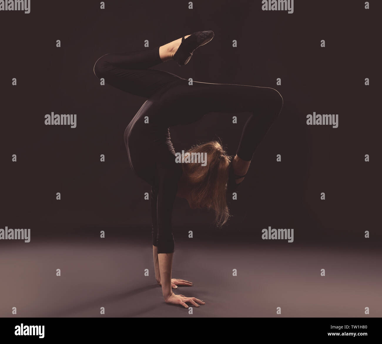 Young girl doing gymnastics on dark background Stock Photo - Alamy