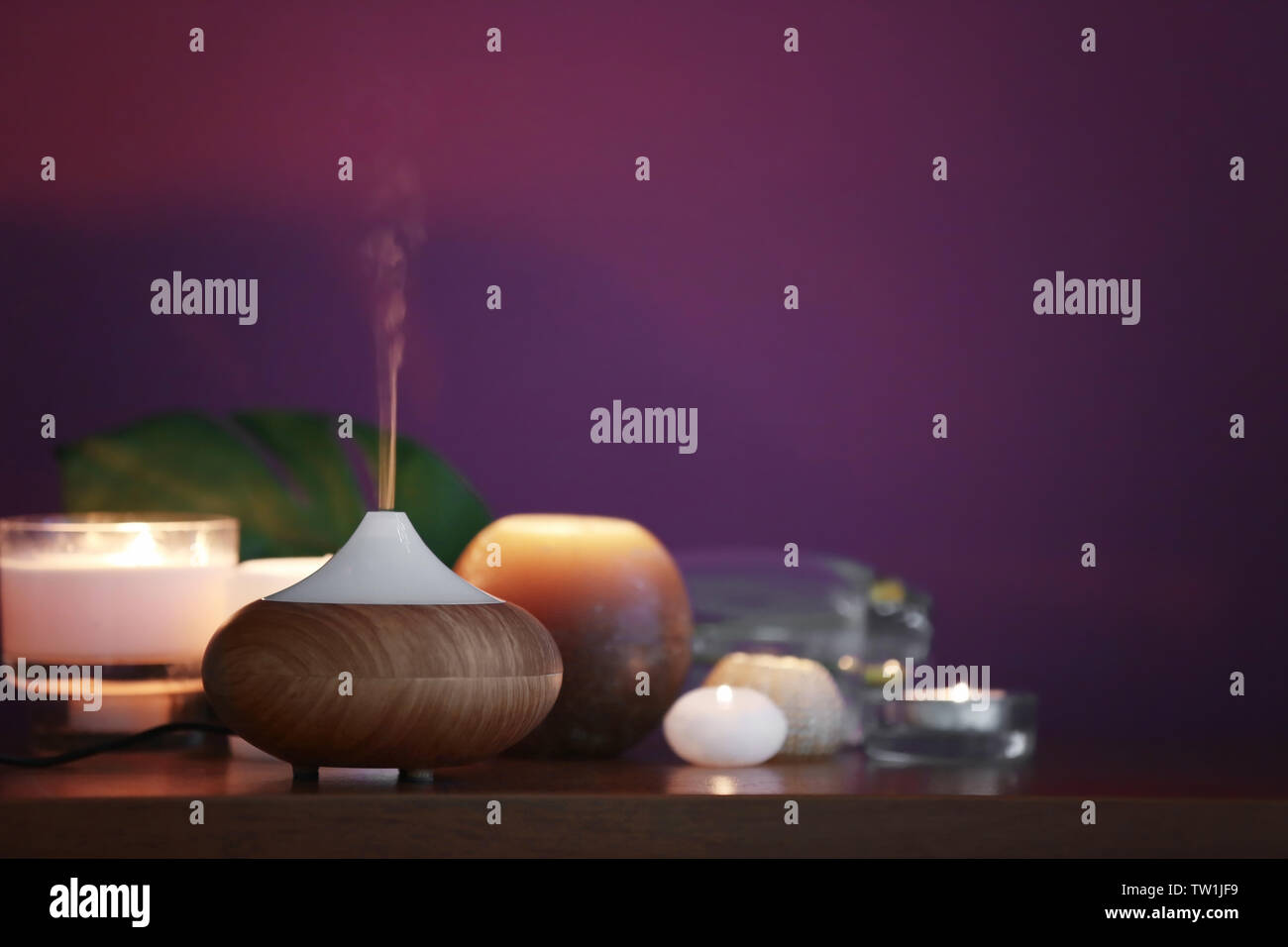 Aroma oil diffuser and candles on table Stock Photo - Alamy