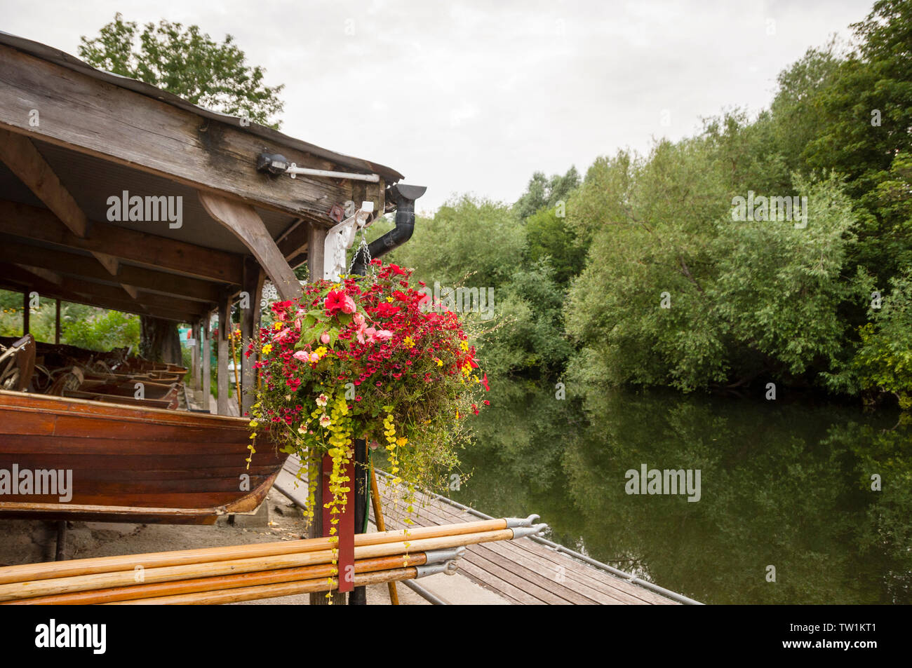 Wooden boat house, wood boats and quant poles along a particularly  picturesque setting on the River Avon in Bath, England. Stock Photo