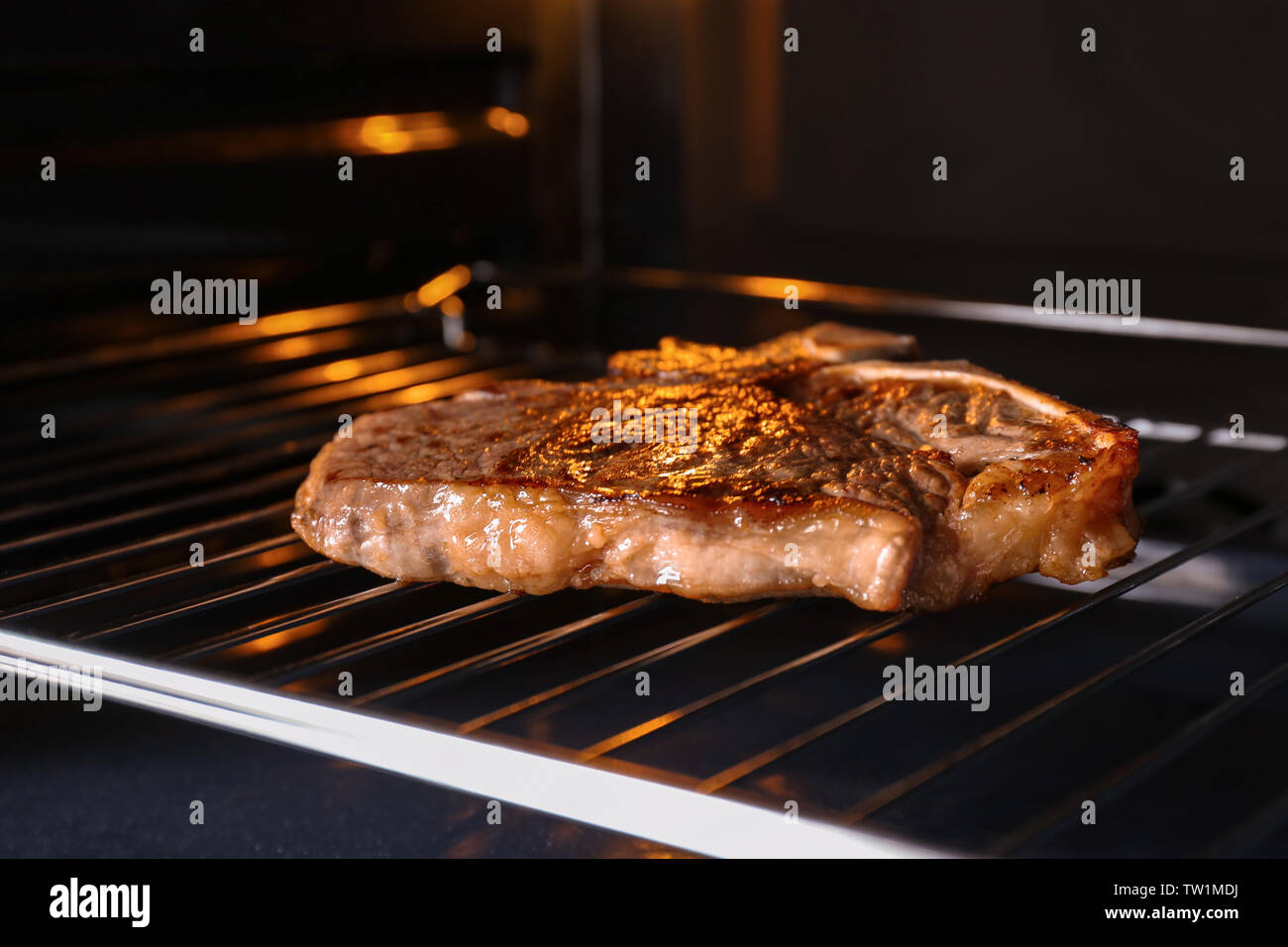Tasty grilled steak in oven Stock Photo - Alamy