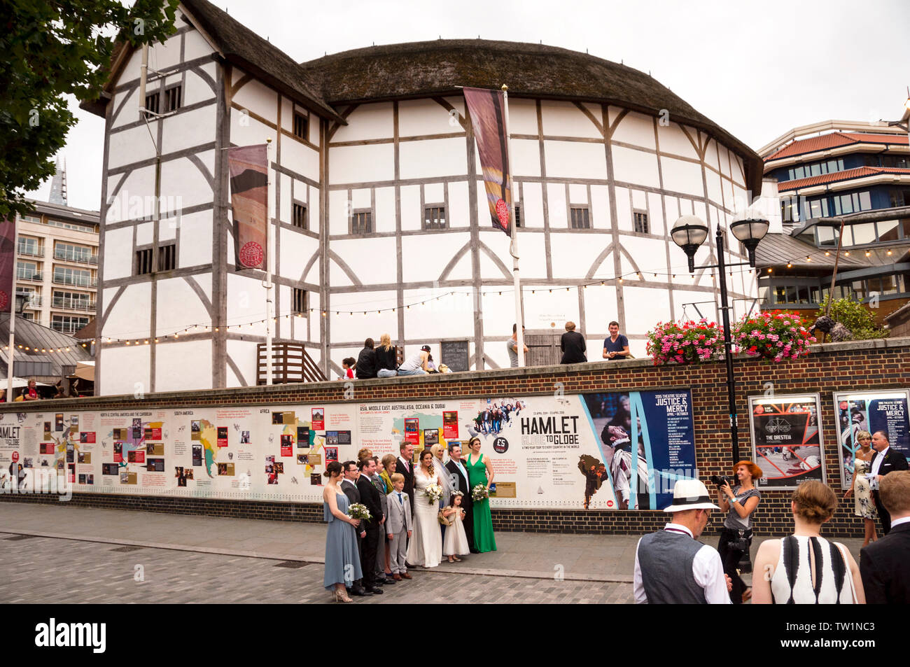 Shakespeare's Globe Theatre in London behind a group posing for wedding photograhy. Stock Photo