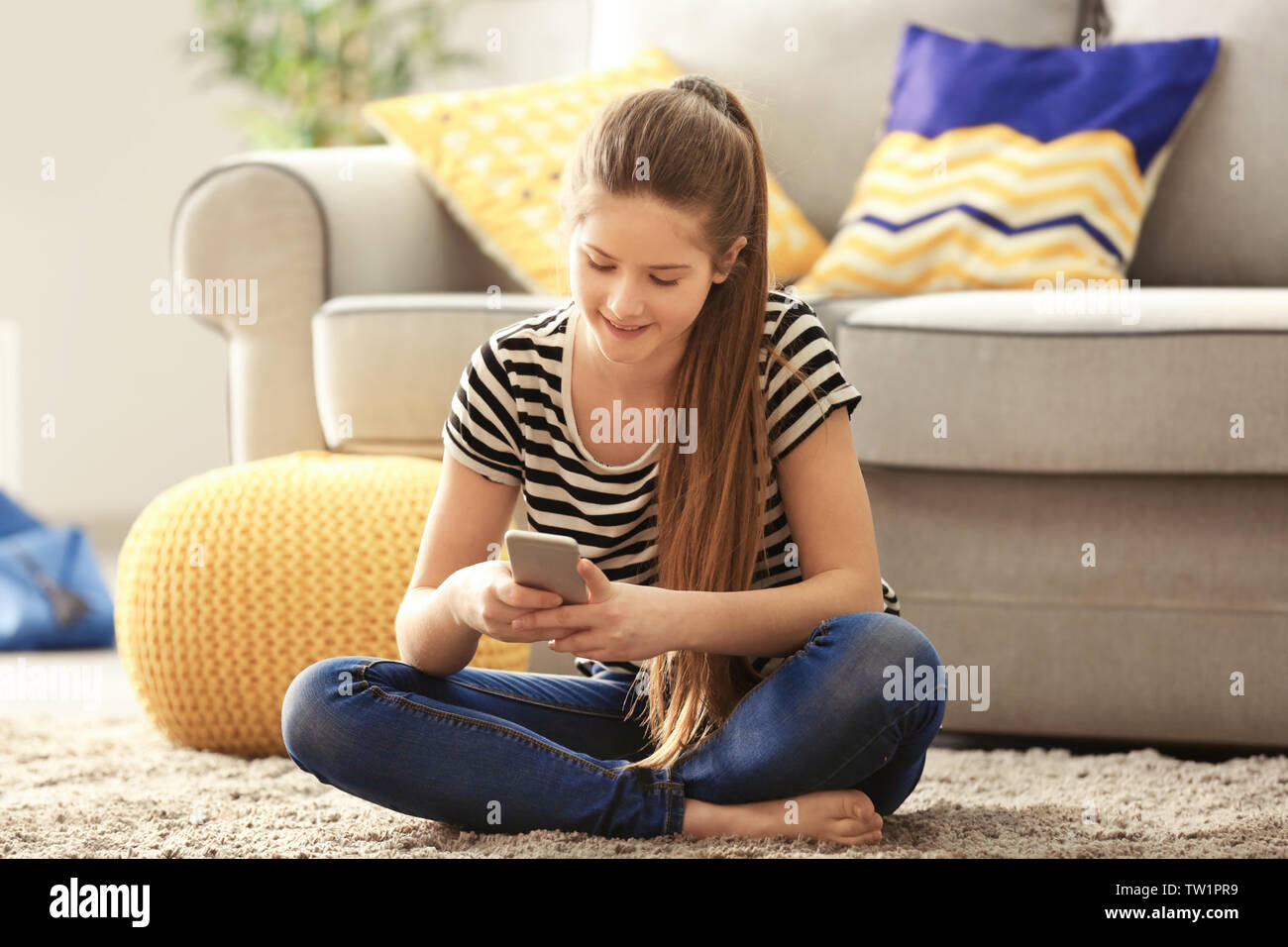 Pretty teenager girl sitting on floor at home Stock Photo - Alamy