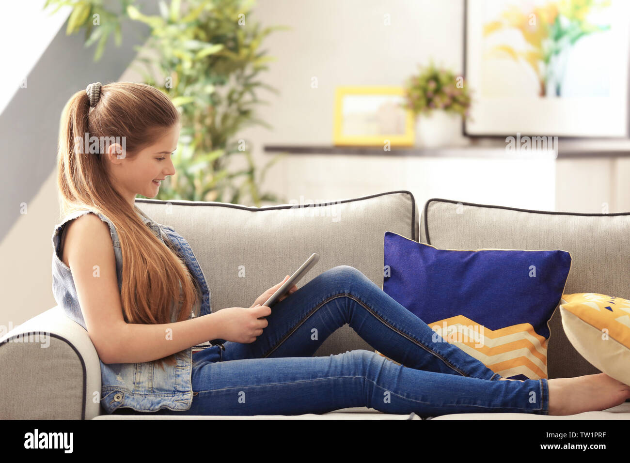 Pretty teenager girl sitting on sofa at home Stock Photo - Alamy