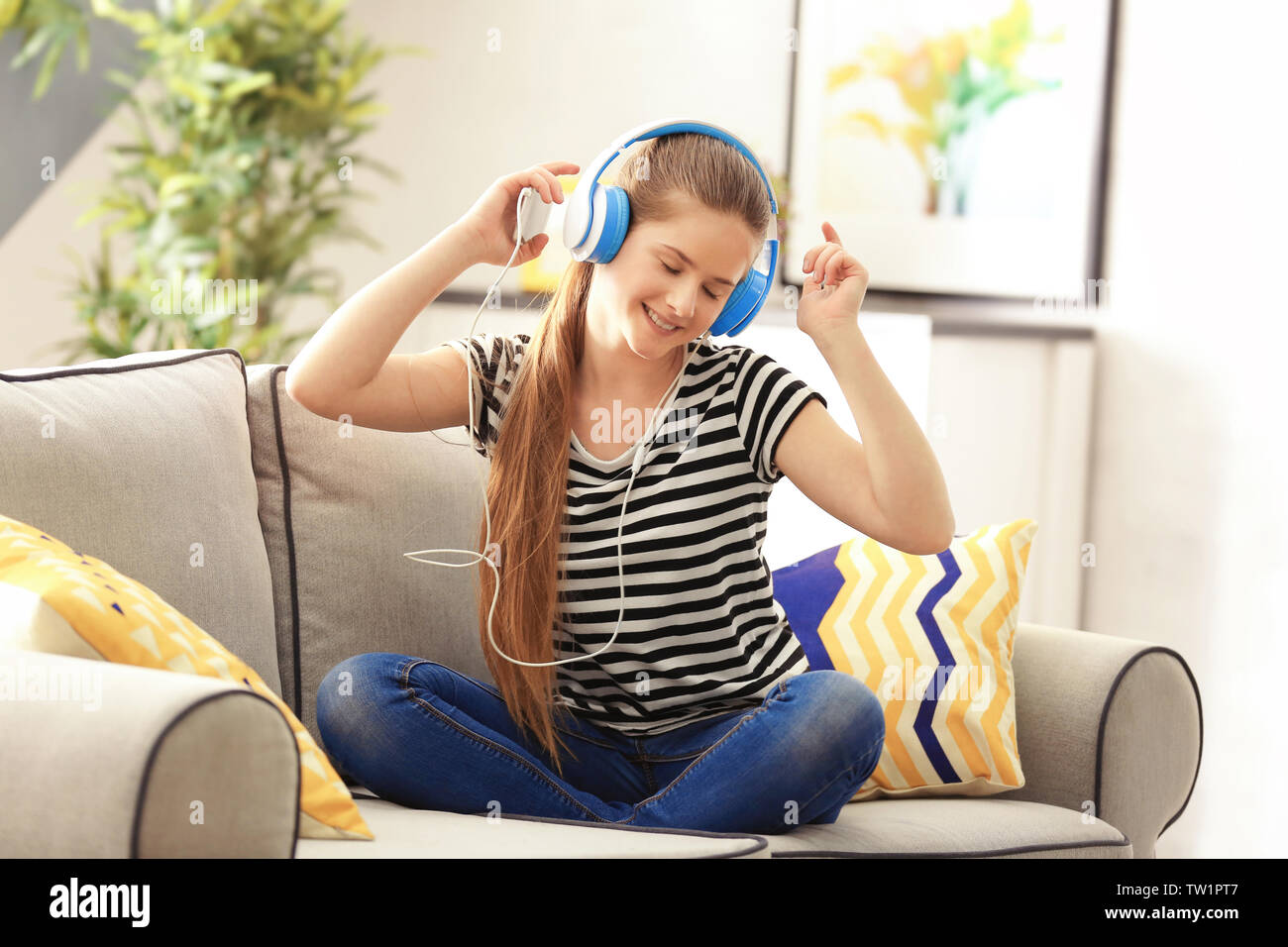 Pretty teenager girl sitting on sofa at home Stock Photo - Alamy