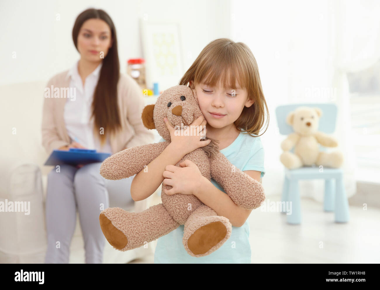 Little girl with teddy bear and child psychologist on background Stock ...