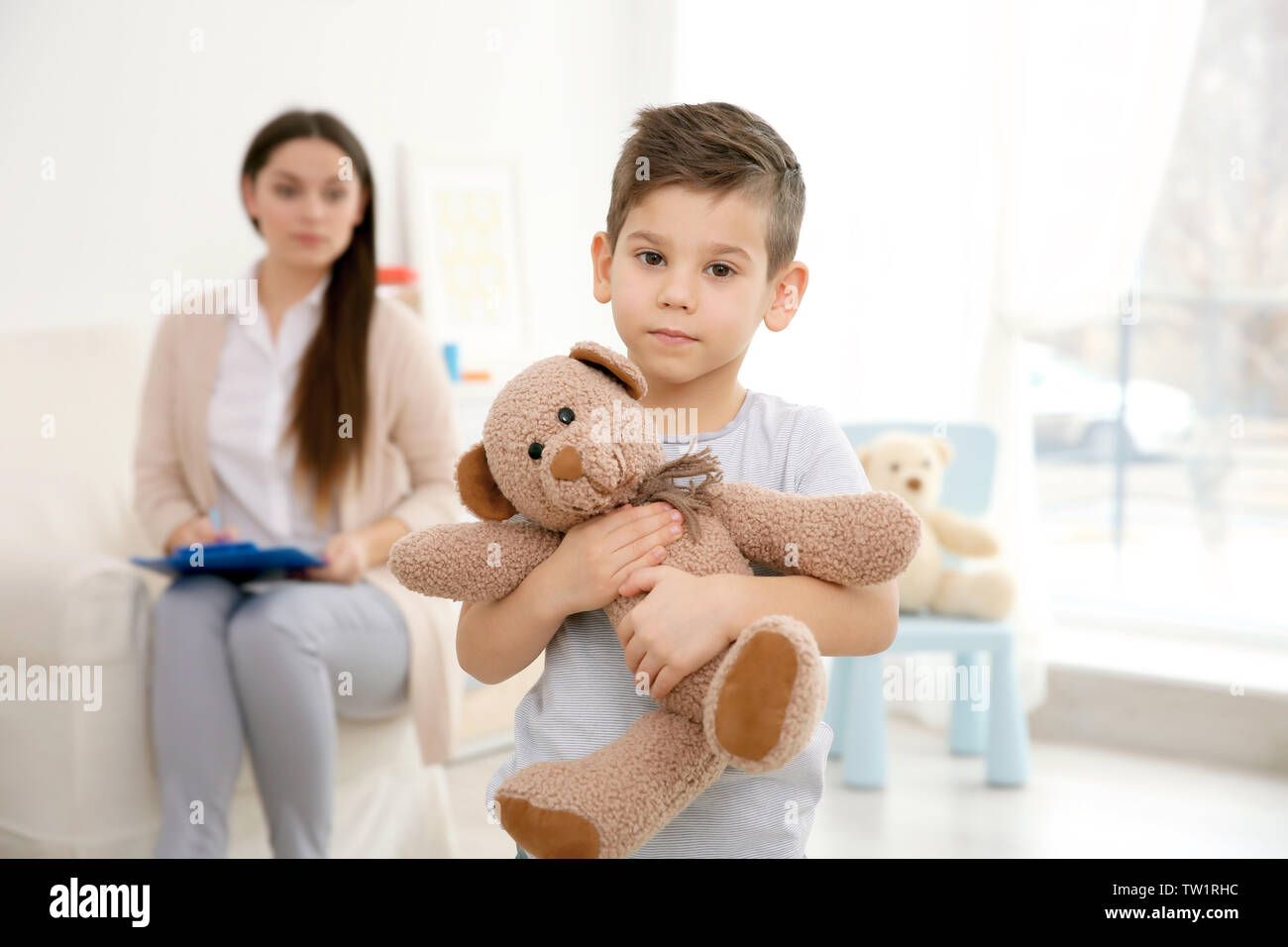 Little boy with teddy bear and child psychologist on background Stock ...