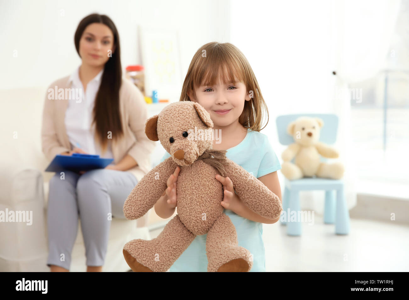 Little girl with teddy bear and child psychologist on background Stock ...