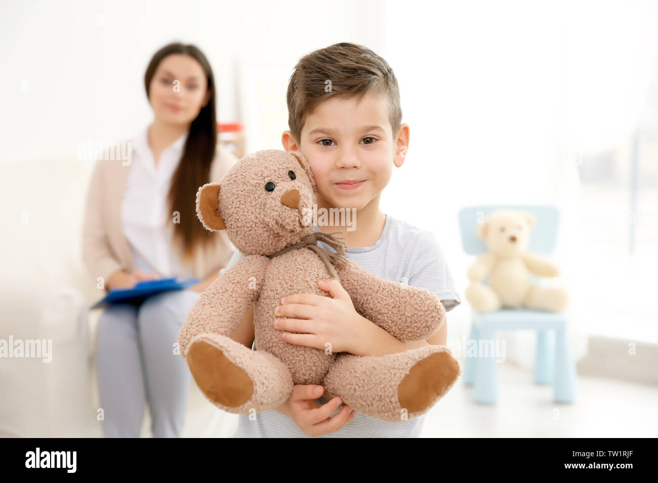 Little boy with teddy bear and child psychologist on background Stock ...