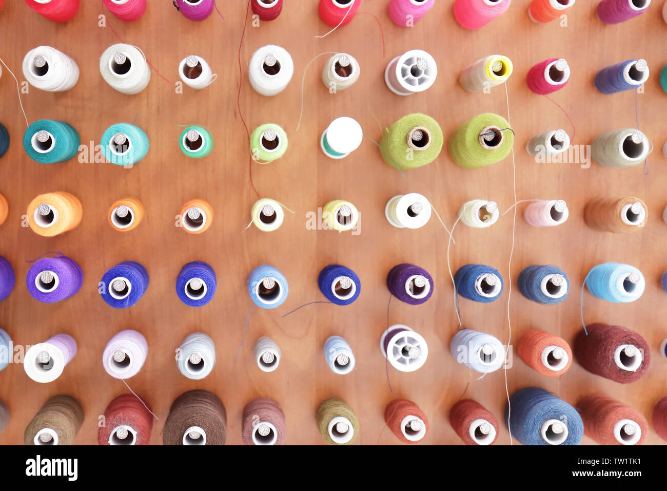Spools with threads on rack, closeup Stock Photo
