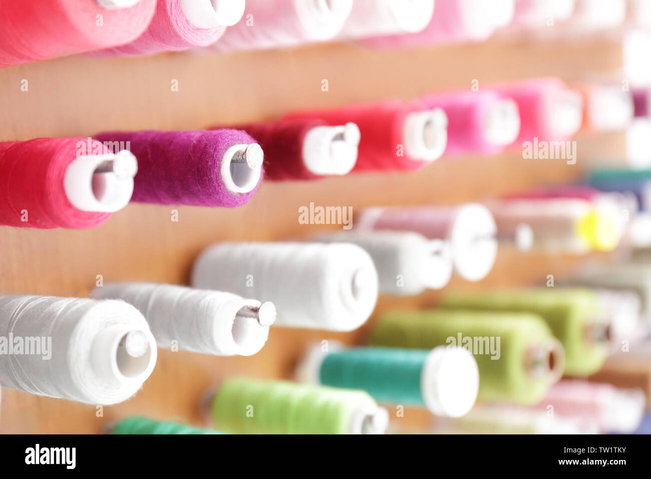 Spools with threads on rack, closeup Stock Photo