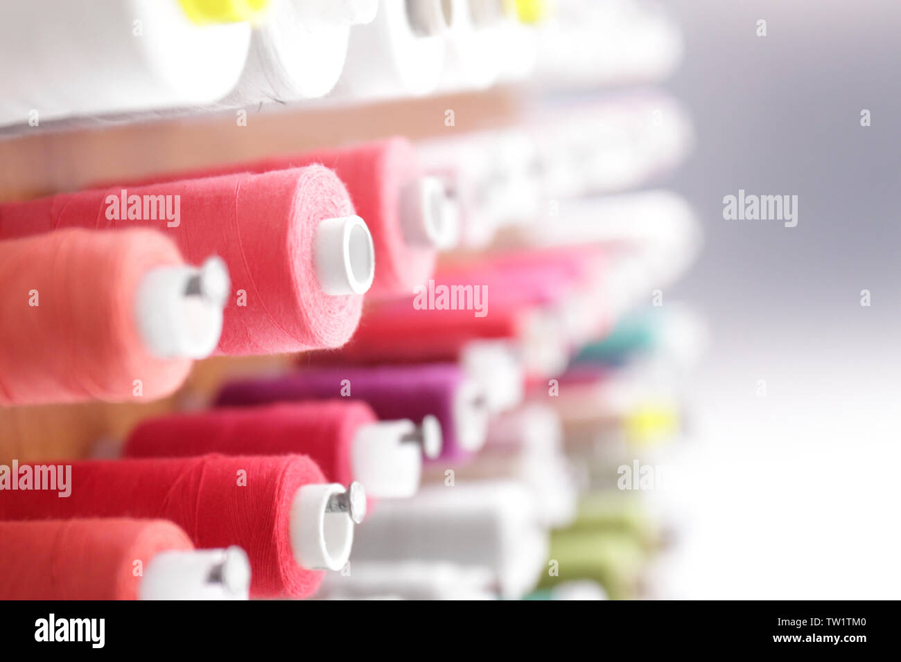 Spools with threads on rack, closeup Stock Photo