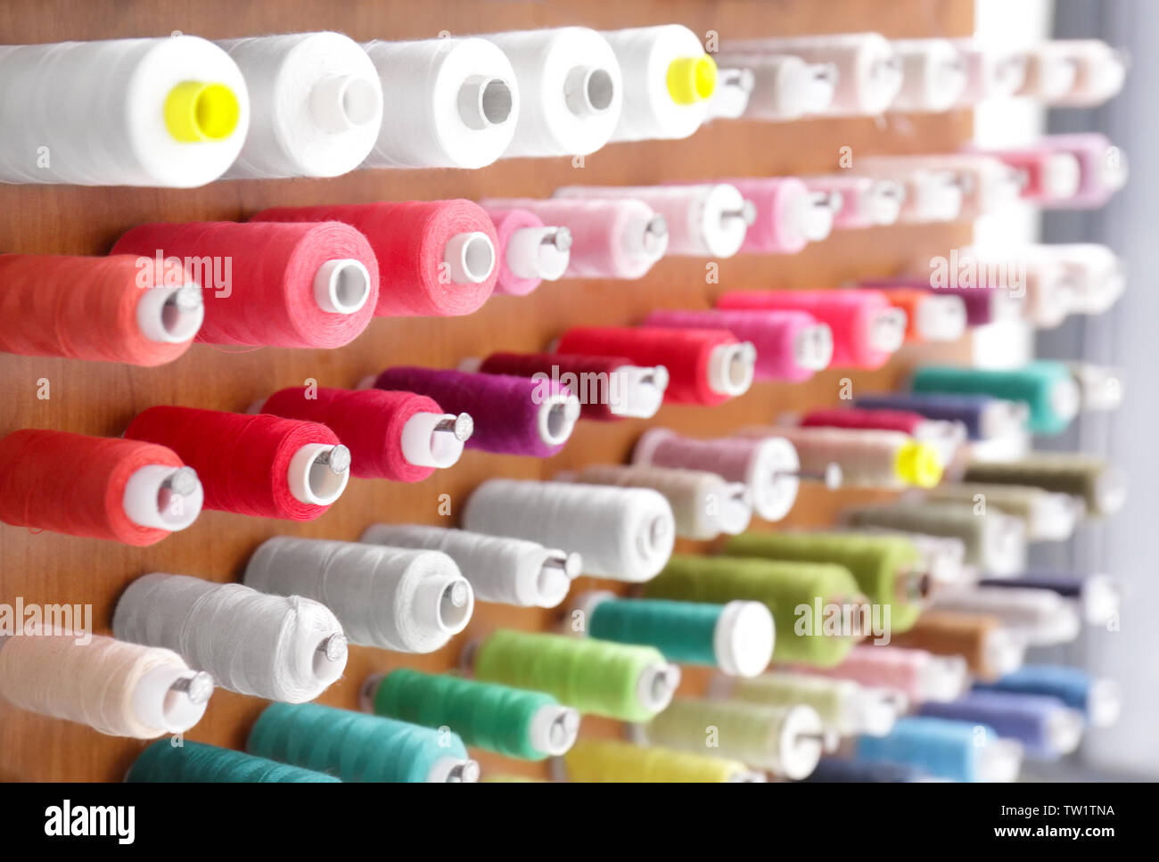 Spools with threads on rack, closeup Stock Photo