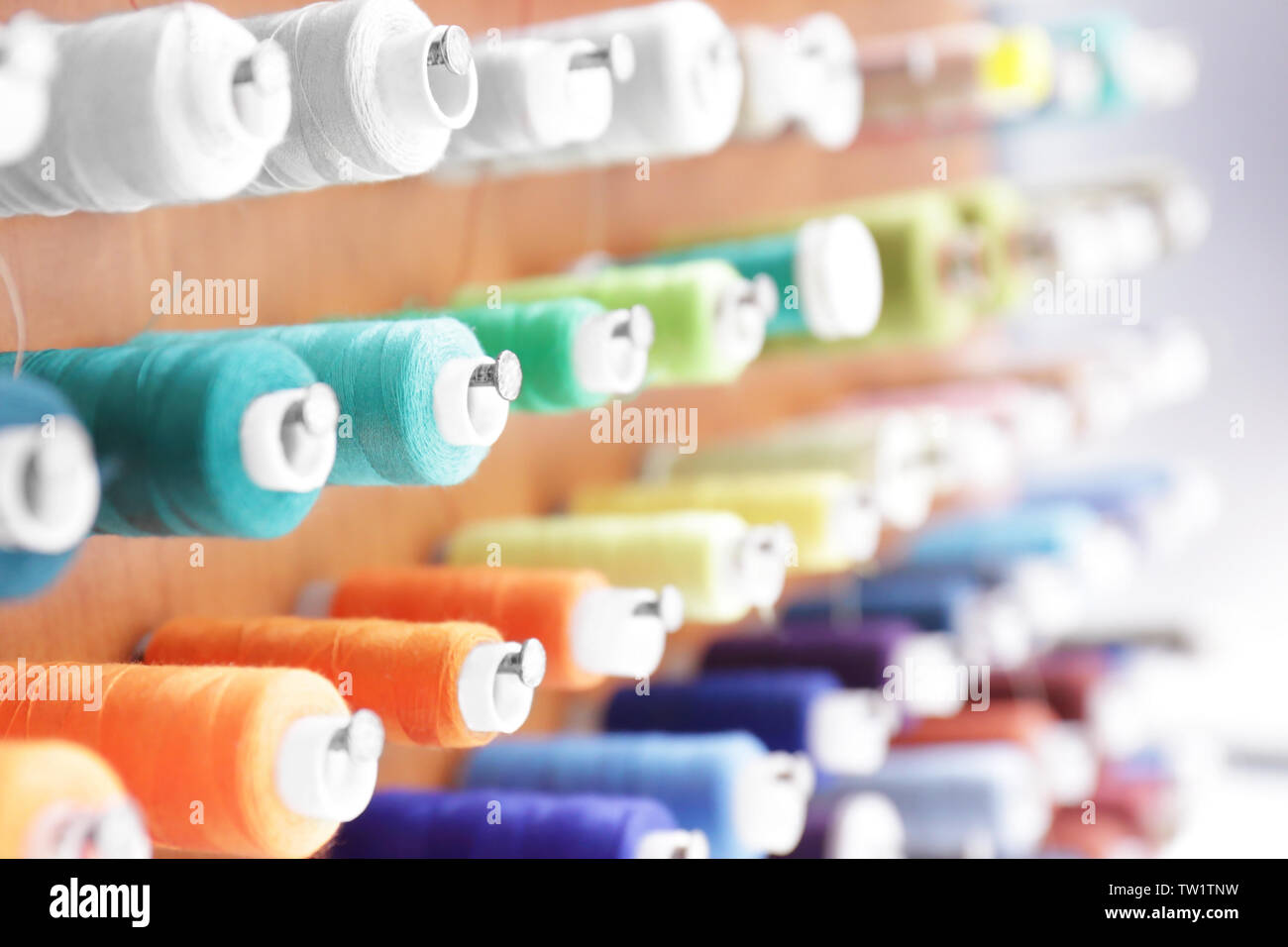 Spools with threads on rack, closeup Stock Photo