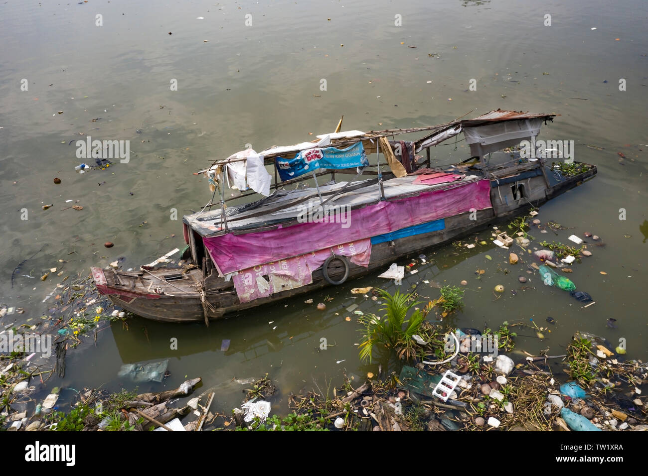 A sunken traditional Vietnamese River Boat (House Boat) in a canal running into the Saigon River in Ho Chi Minh City, Vietnam. Loss and tragedy Stock Photo