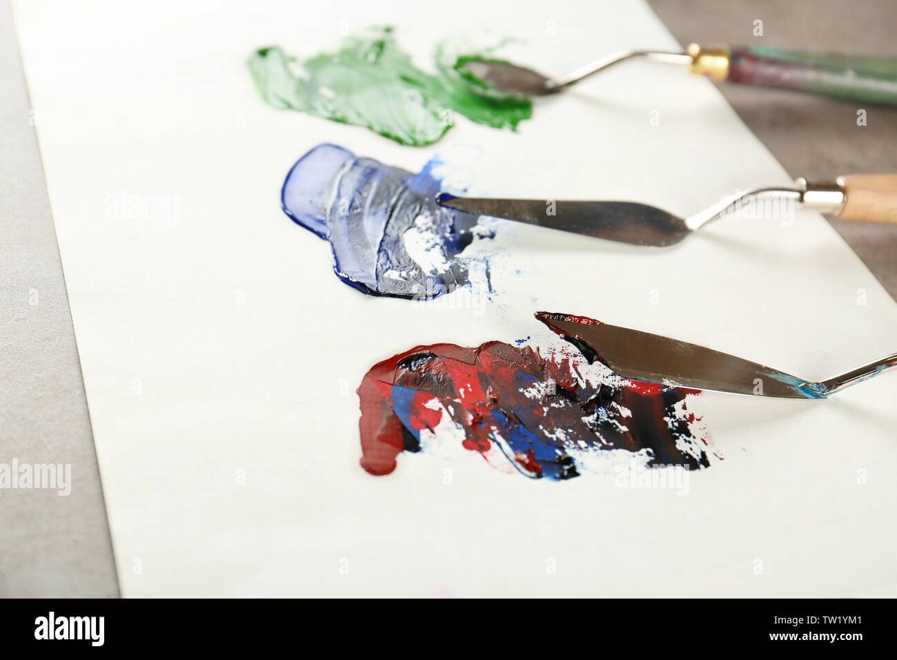 Palette knives with paint on paper Stock Photo Alamy
