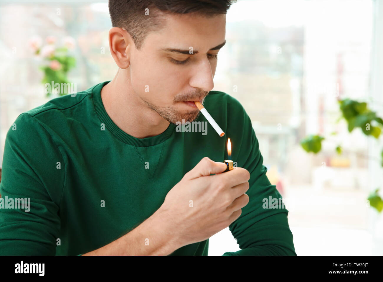 person lighting cigarette Young man at dusk A person lights a cigarette