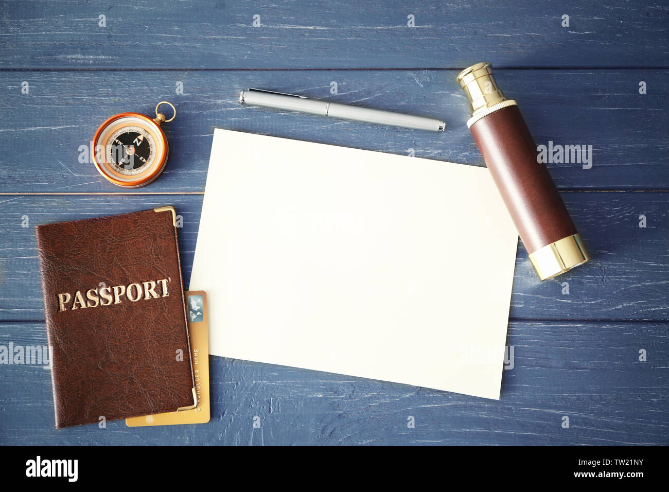 Travel concept. Passport, blank notepad page, compass and spyglass on wooden background Stock Photo
