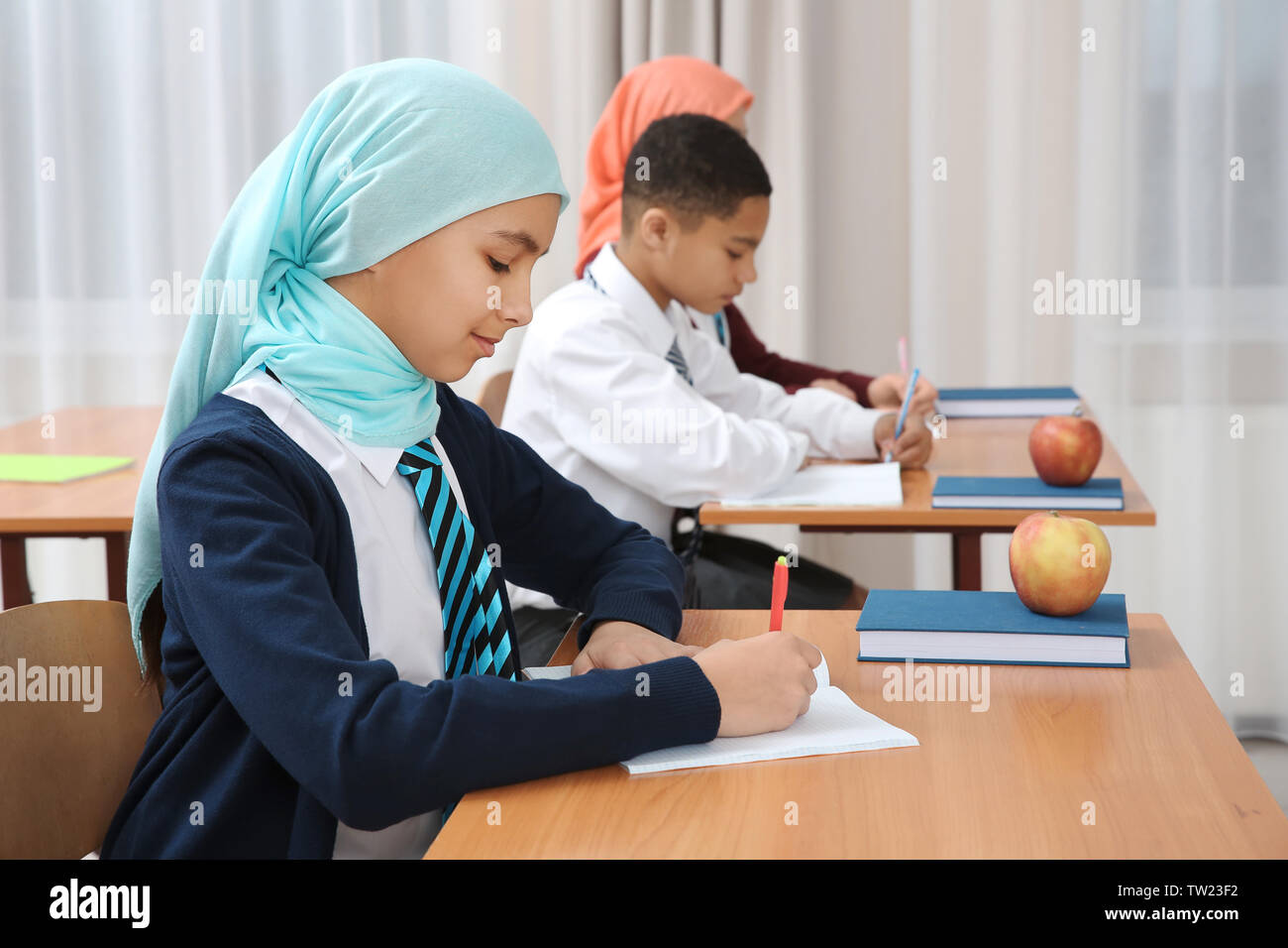 Cute girl sitting at desk in school class Stock Photo - Alamy