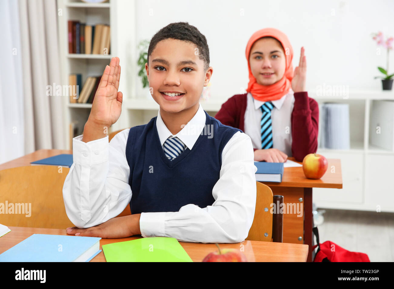 Cute schoolboy sitting at desk in classroom Stock Photo - Alamy