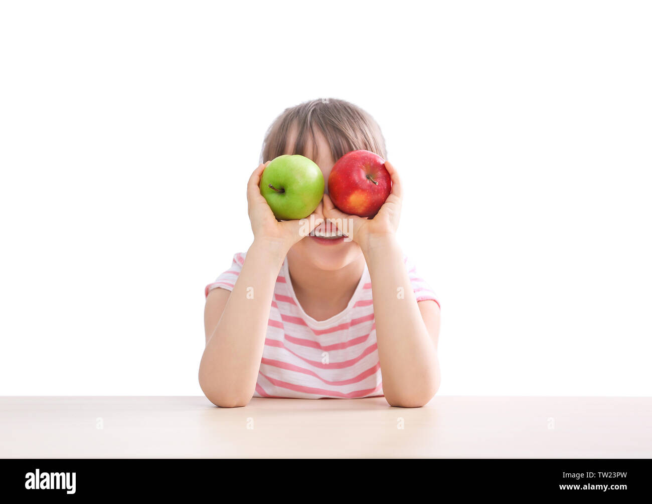 Happy schoolgirl sitting with apples at table on white background Stock ...