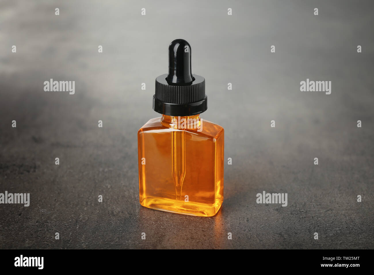 Bottle with perfume oil on grunge background Stock Photo