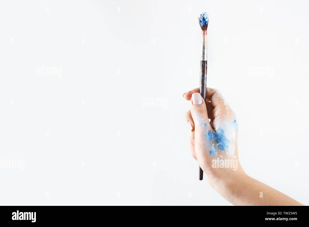 Female hand holding brush on light background Stock Photo - Alamy